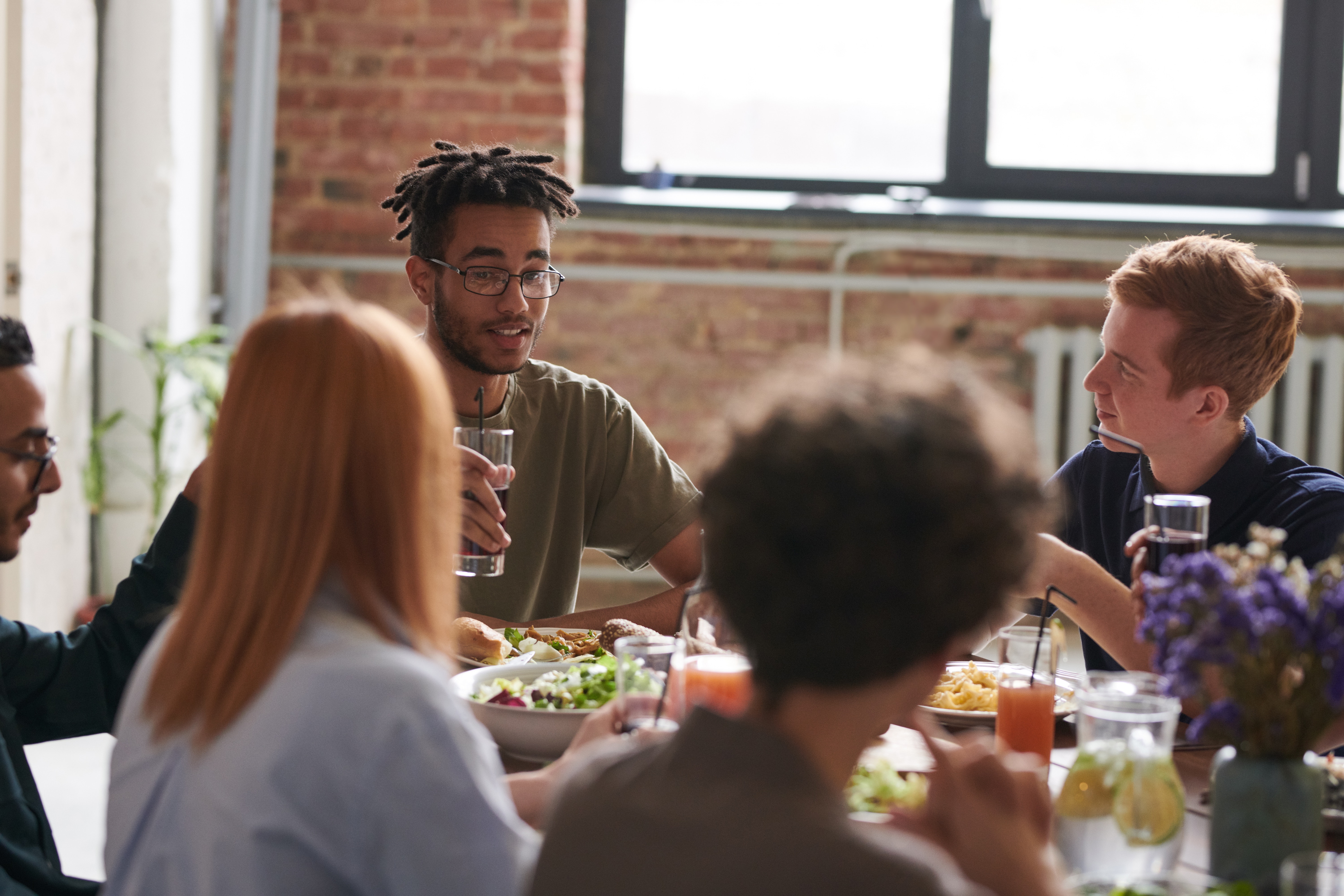 Group of friends eating and drinking at a table 