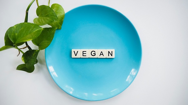 Blue plate with vegan written with scrabble letters 