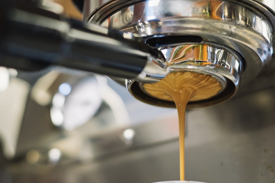 latte being poured out of a commercial coffee machine