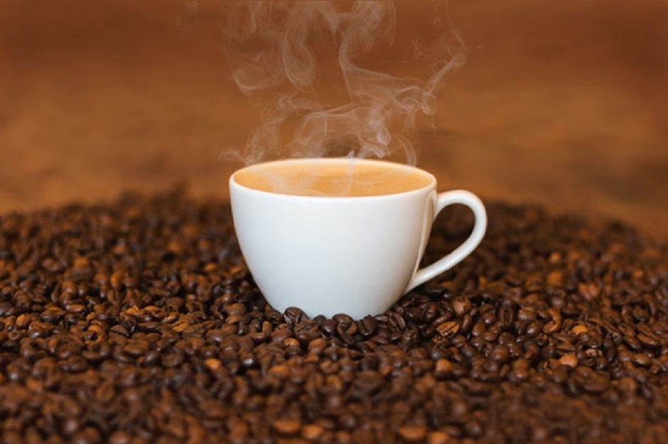 steaming hot coffee on coffee beans